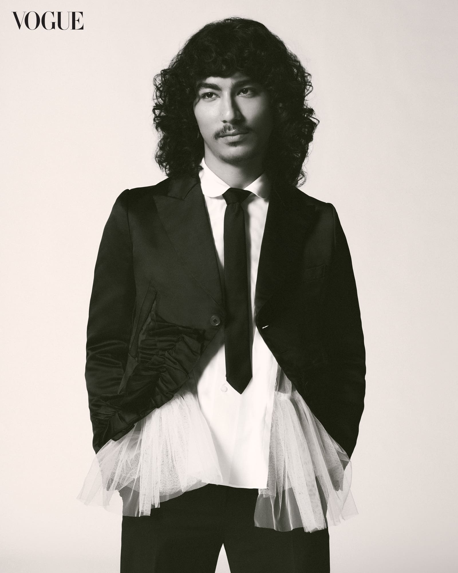 Jason Dhakal wears a COMME DES GARÇONS suit and shirt.