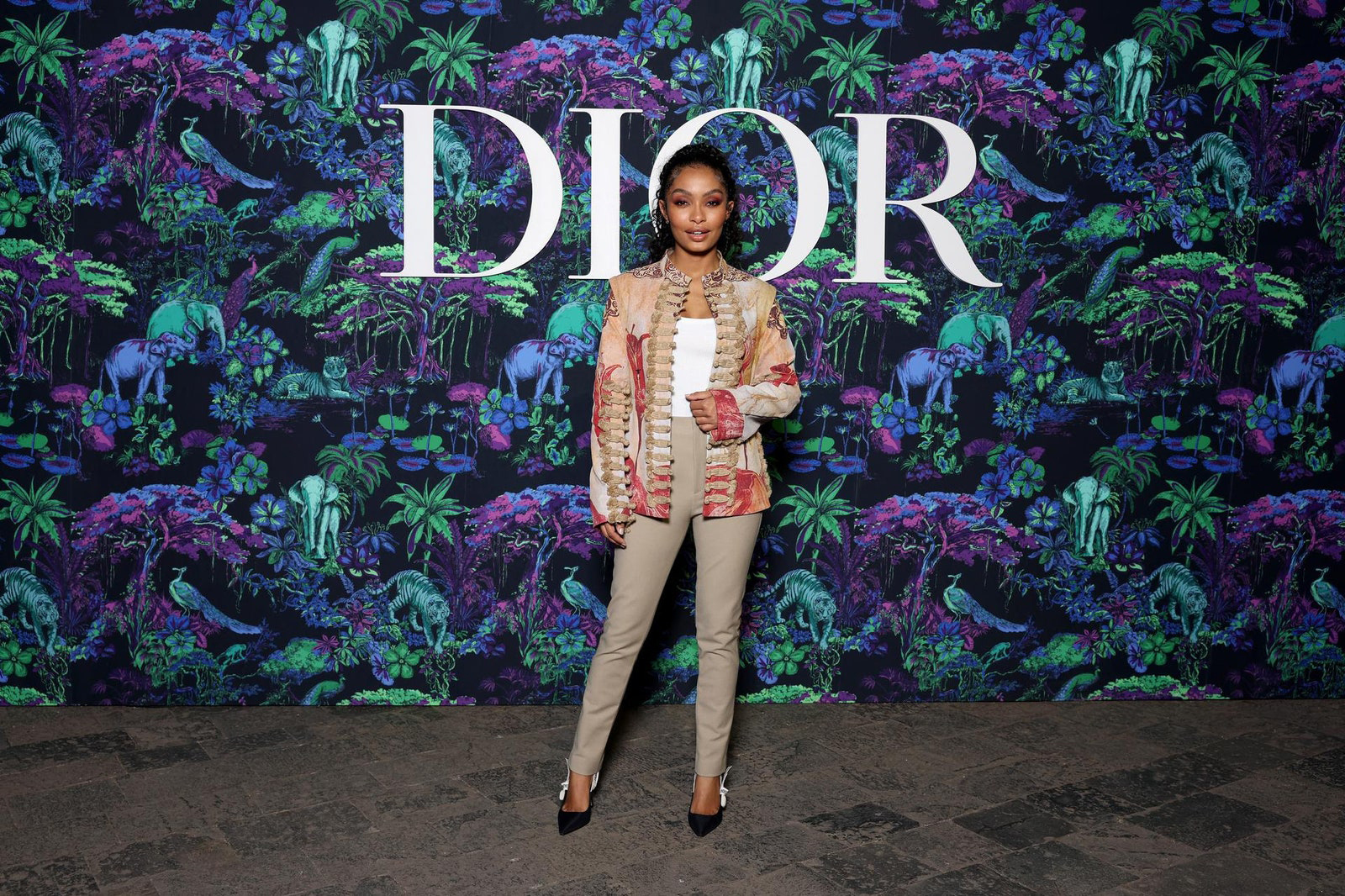 Dior Fall/Winter 2023 Show In Mumbai Yara Shahidi wore a Dior Cruise 2023 printed embroidered jacket with a white cotton shirt and beige wool and silk pants.