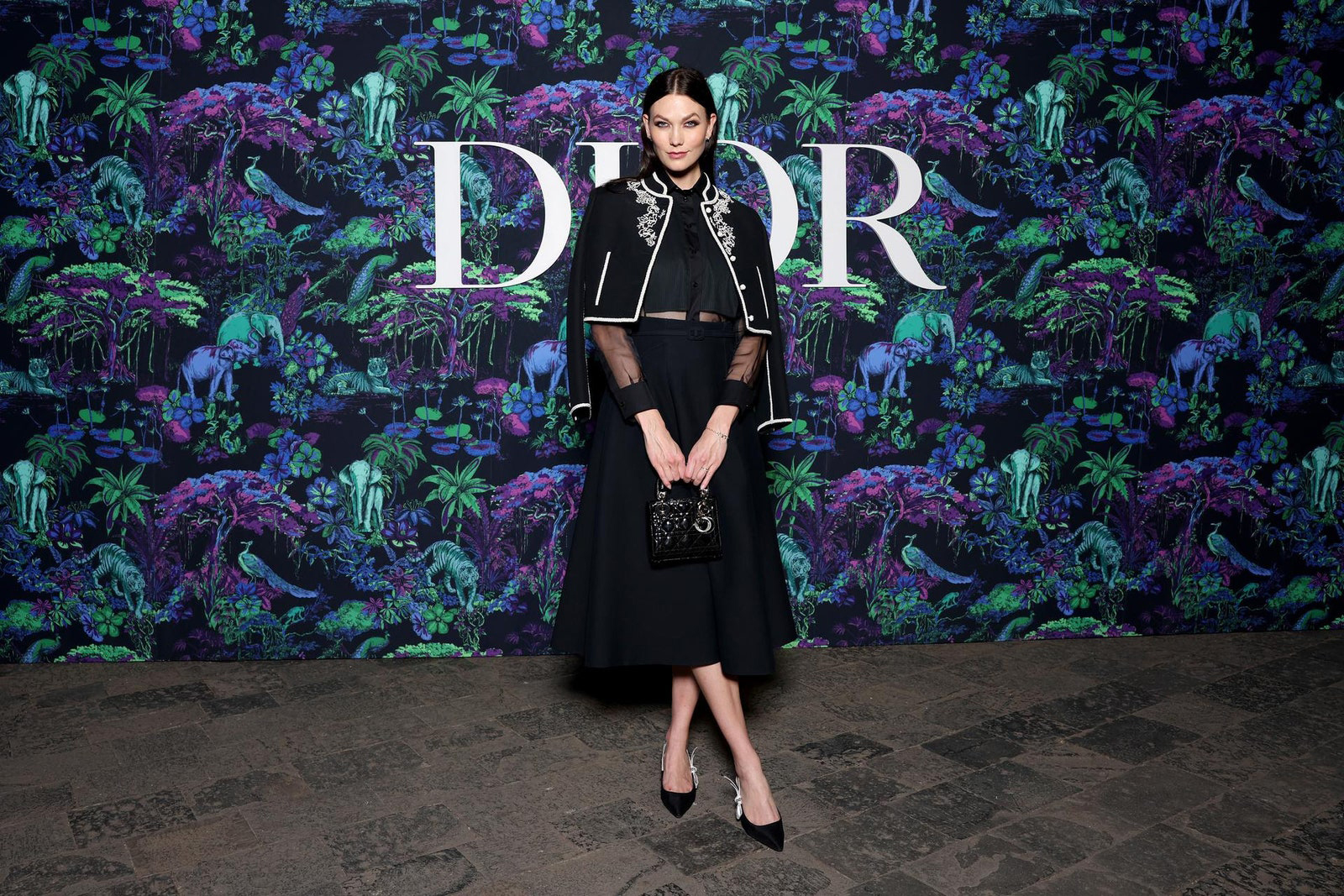 Dior Fall/Winter 2023 Show In Mumbai Karlie Kloss wore a Dior Cruise 2023 black embroidered wool jacket, black silk shirt and a black wool skirt.