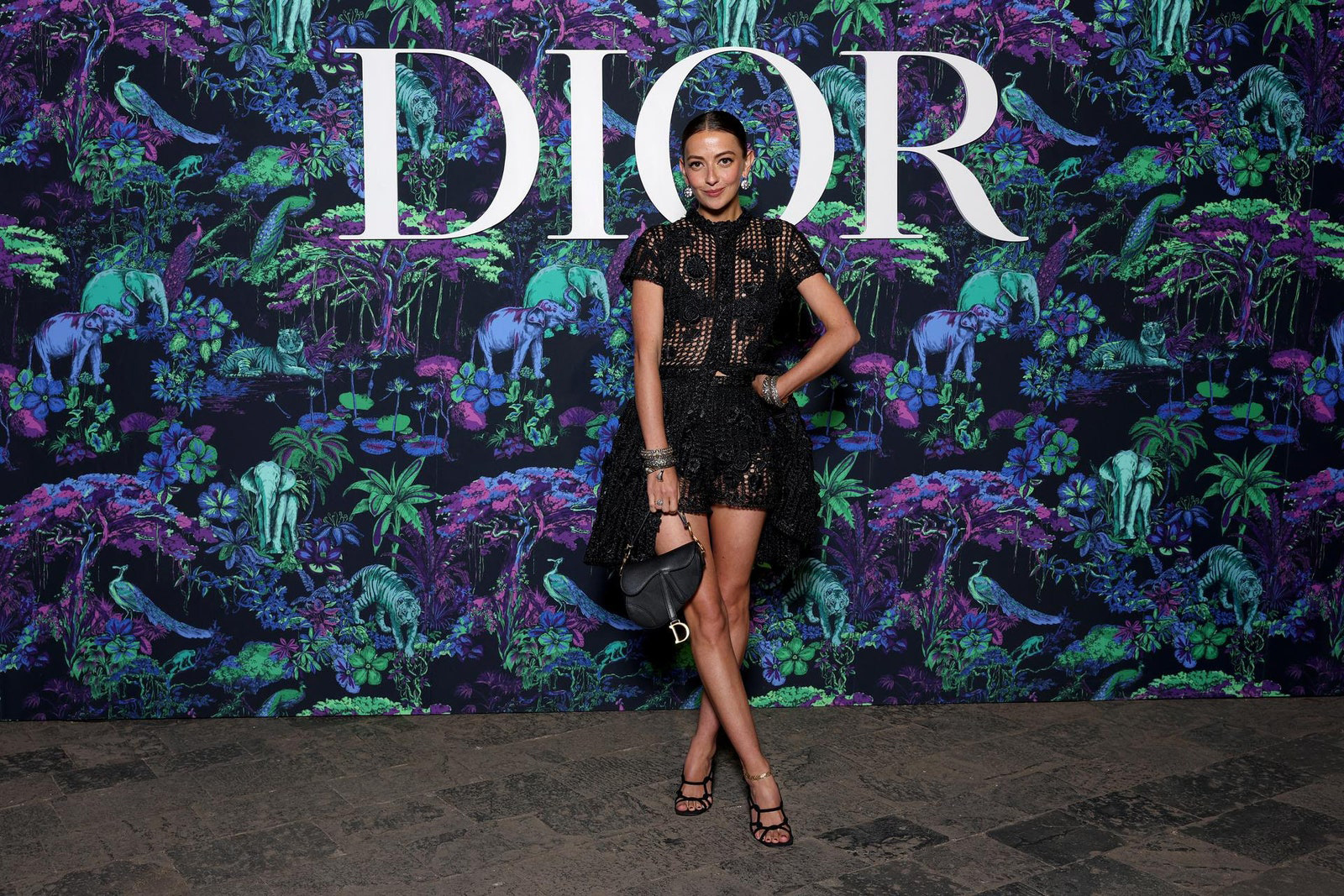 Dior Fall/Winter 2023 Show In Mumbai Claire Deboo wore a Dior Spring-Summer 2023 black raffia dress with a Dior bag and shoes.