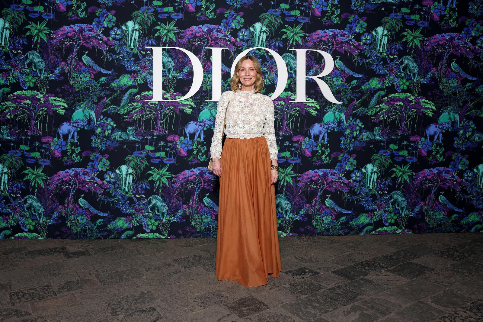 Dior Fall/Winter 2023 Show In Mumbai Lucie de la Falaise wore a Dior white lace top with orange silk taffeta skirt.