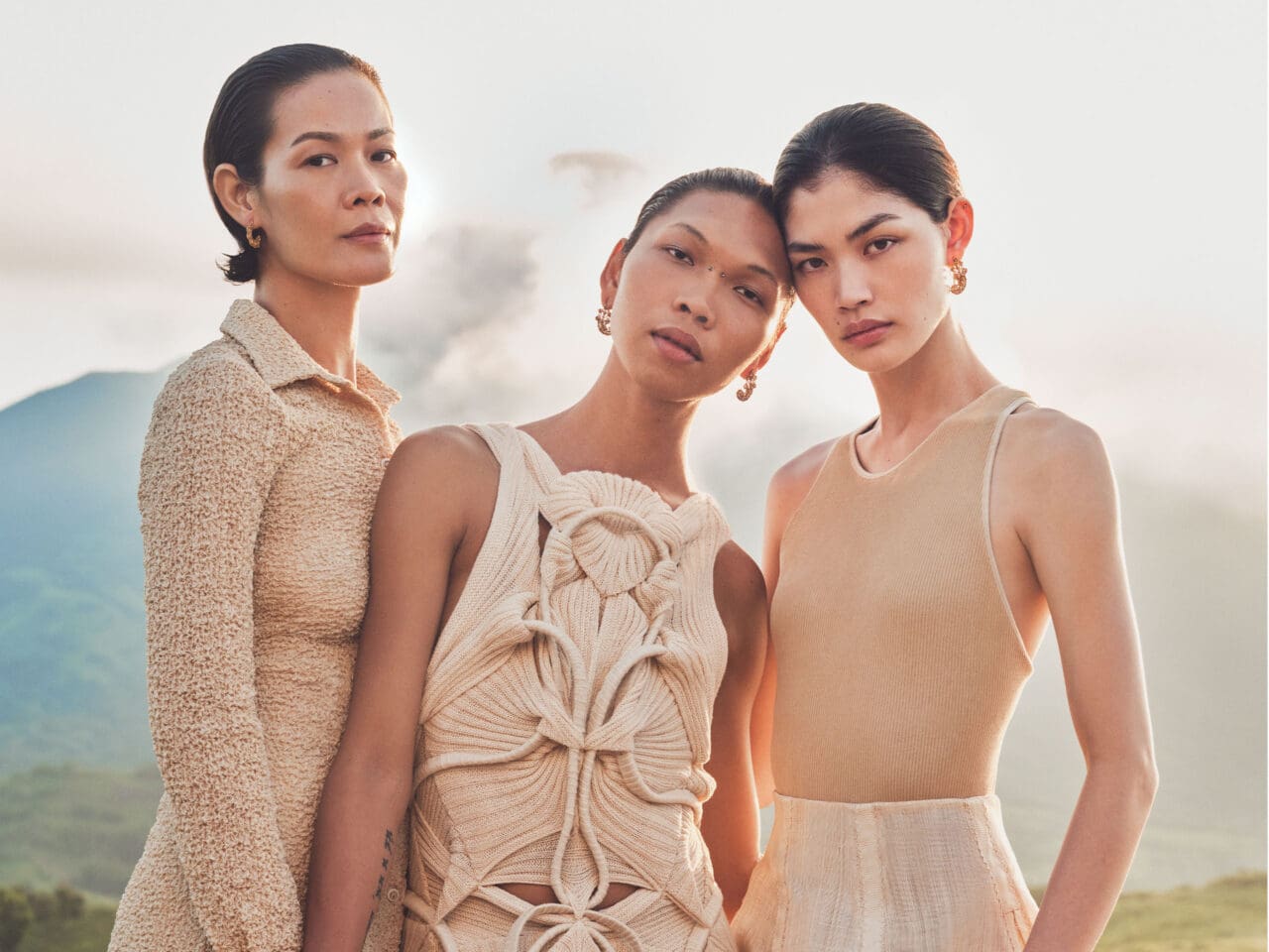 Rina, Lukresia, and Jo Ann wear NOVEL deconstructed puffer dresses molded from deadstock fabric to complement the female form through ruching and quilting manipulations, MELITTA BAUMEISTER white quilt skirt. All wear Ivatan Tukap rope sandals.