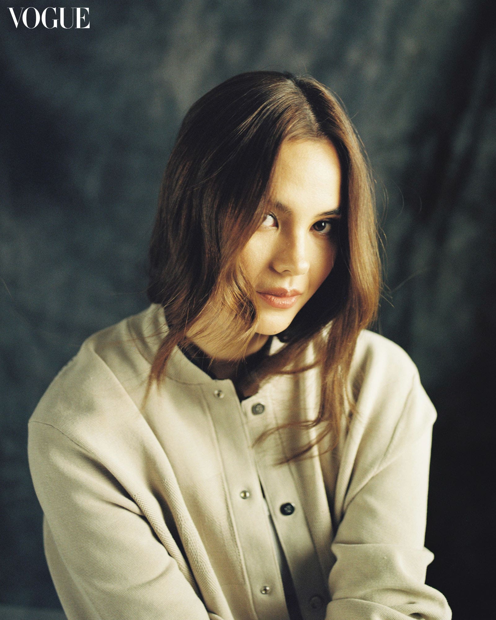 a portrait of Catriona Gray wearing a jacket against a dark blue background