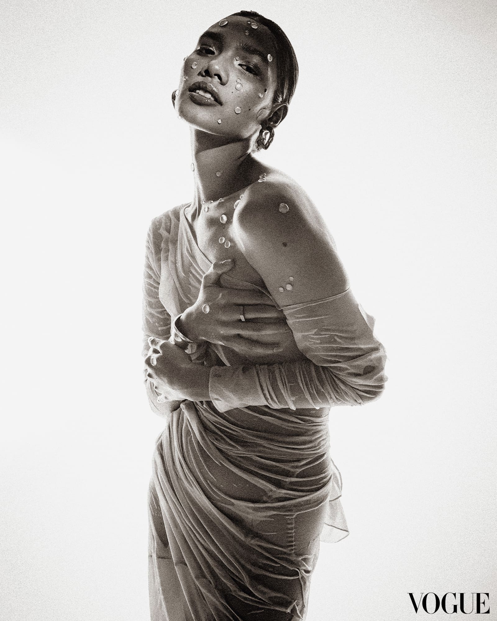 a black and white portrait of a woman wearing wet clothes with jewels on her face