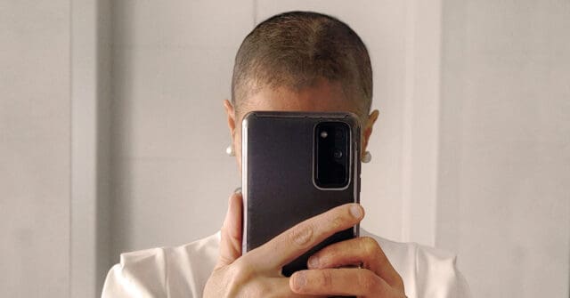 A woman taking a photo of herself in front of the mirror