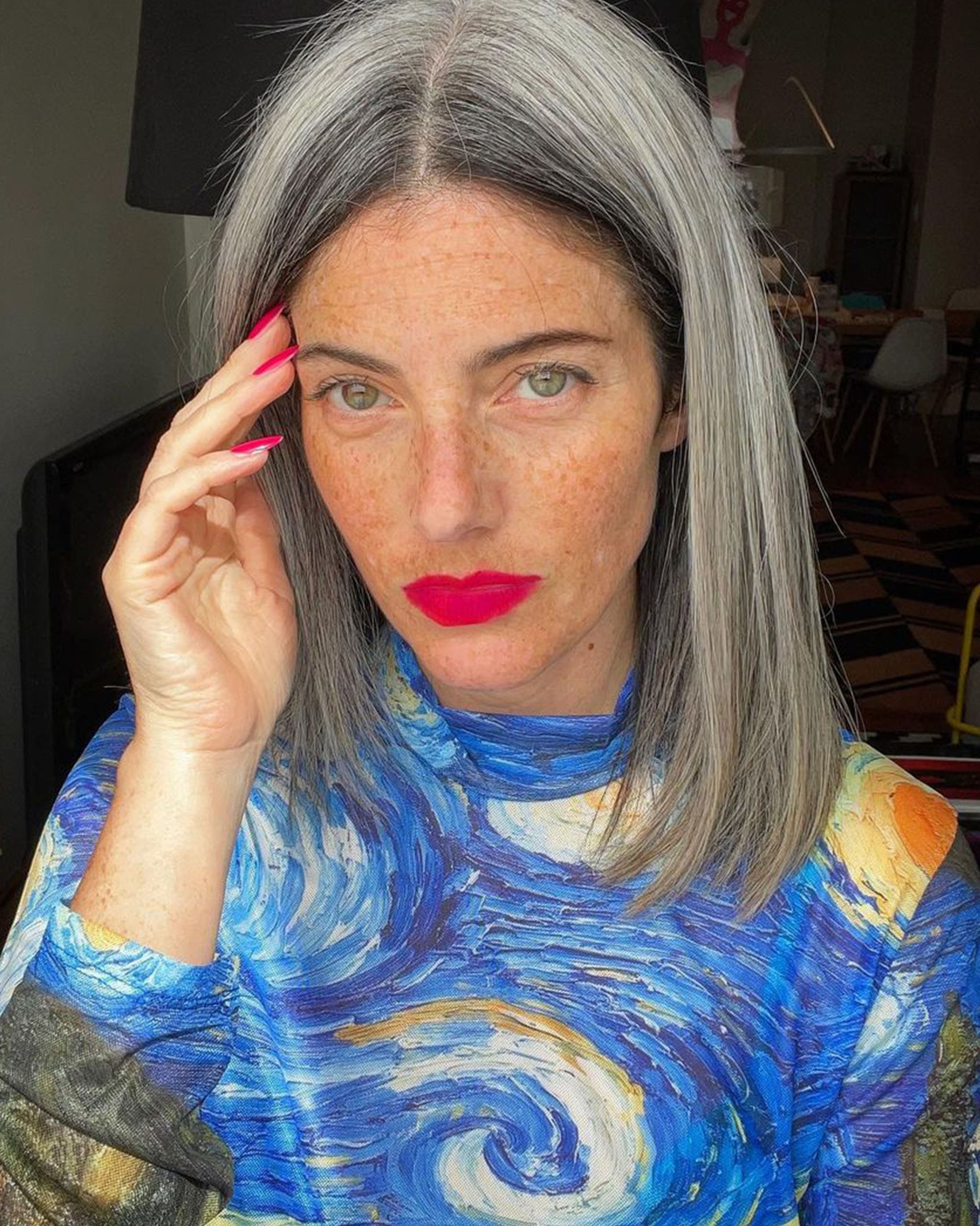 A woman with a Vincent Van Gogh top and grey hair