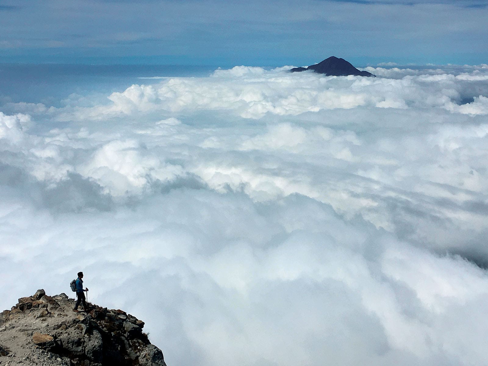 A man staring at clouds by the edge of Mountain Pulag