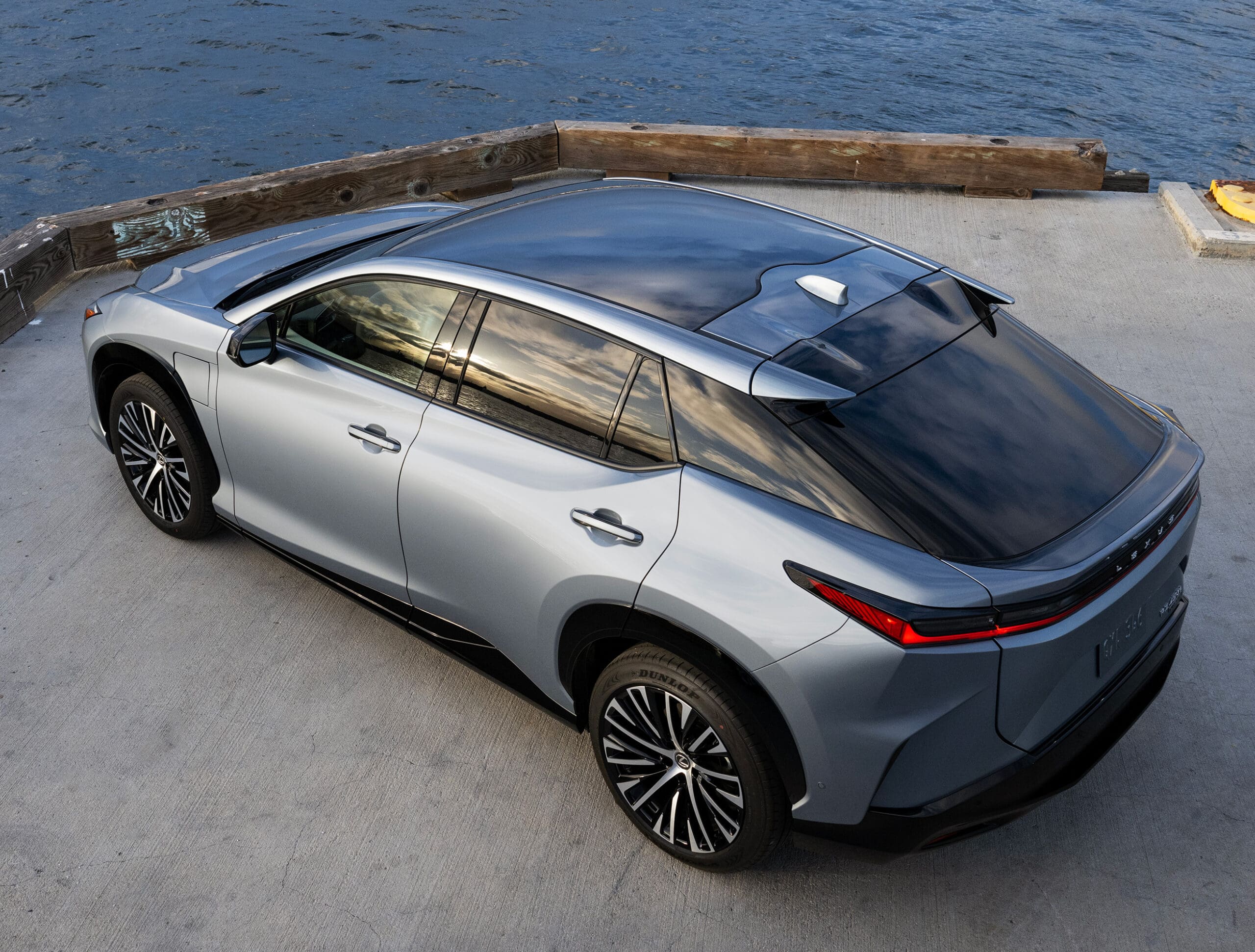 The silver gray Lexus RZ parked by a port