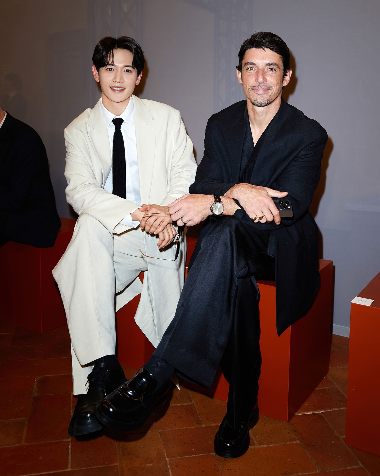 Minho Choi and Alberto Guerra in white and black ensembles, respectively, at the COS Runway at Corsie Sistine, Italy