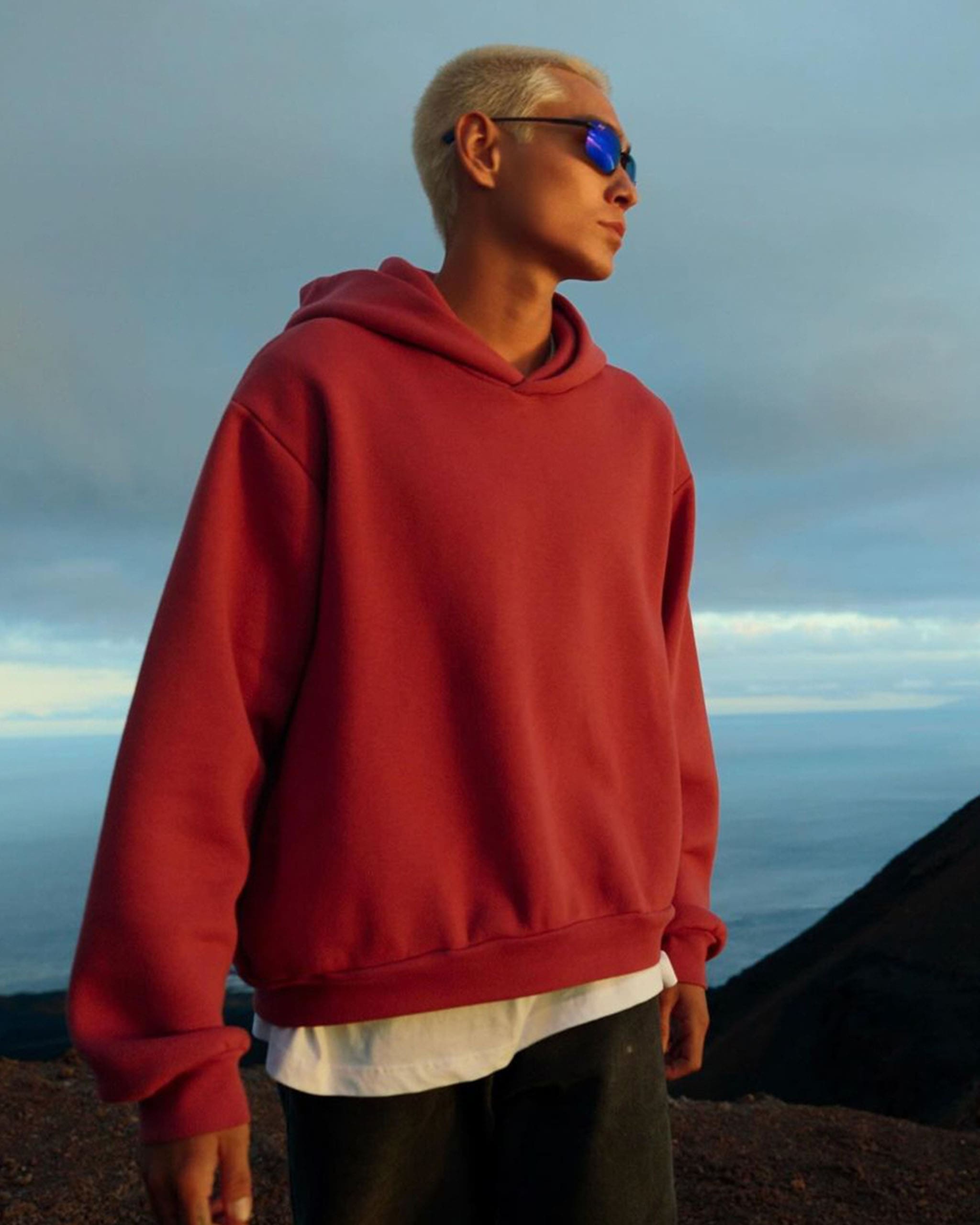 Evan Mock wearing a blue and black Maui Jim and red oversized hoodie