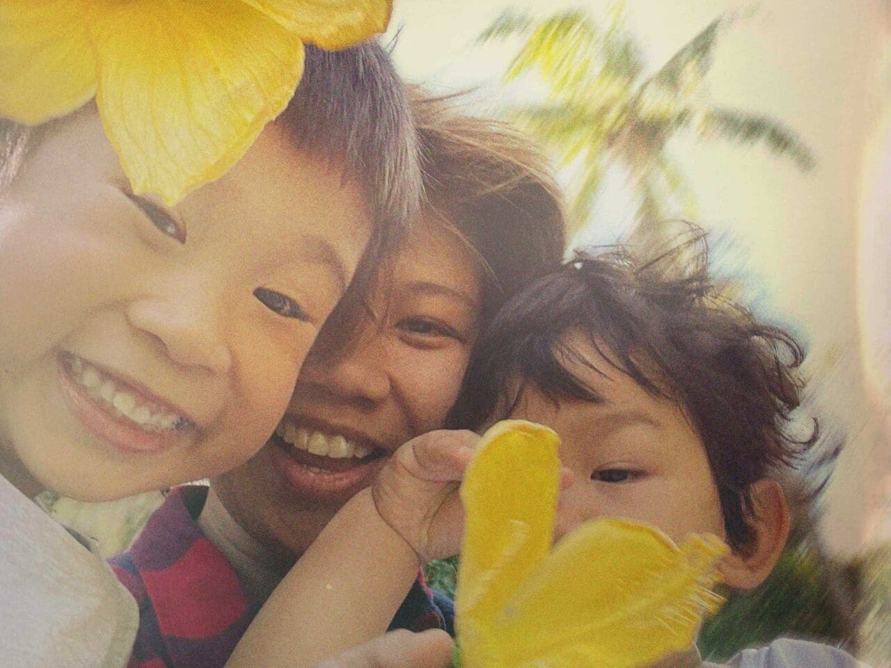 Alee Garibay with her two male children holding yellow flowers