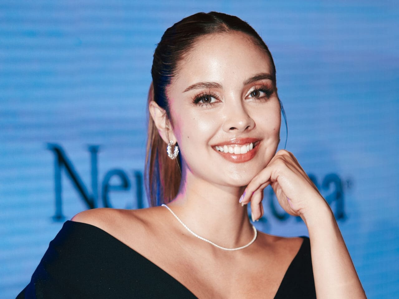 Megan Young wearing a black dress and diamond jewelry at the Neutrogena Visible Repair launch