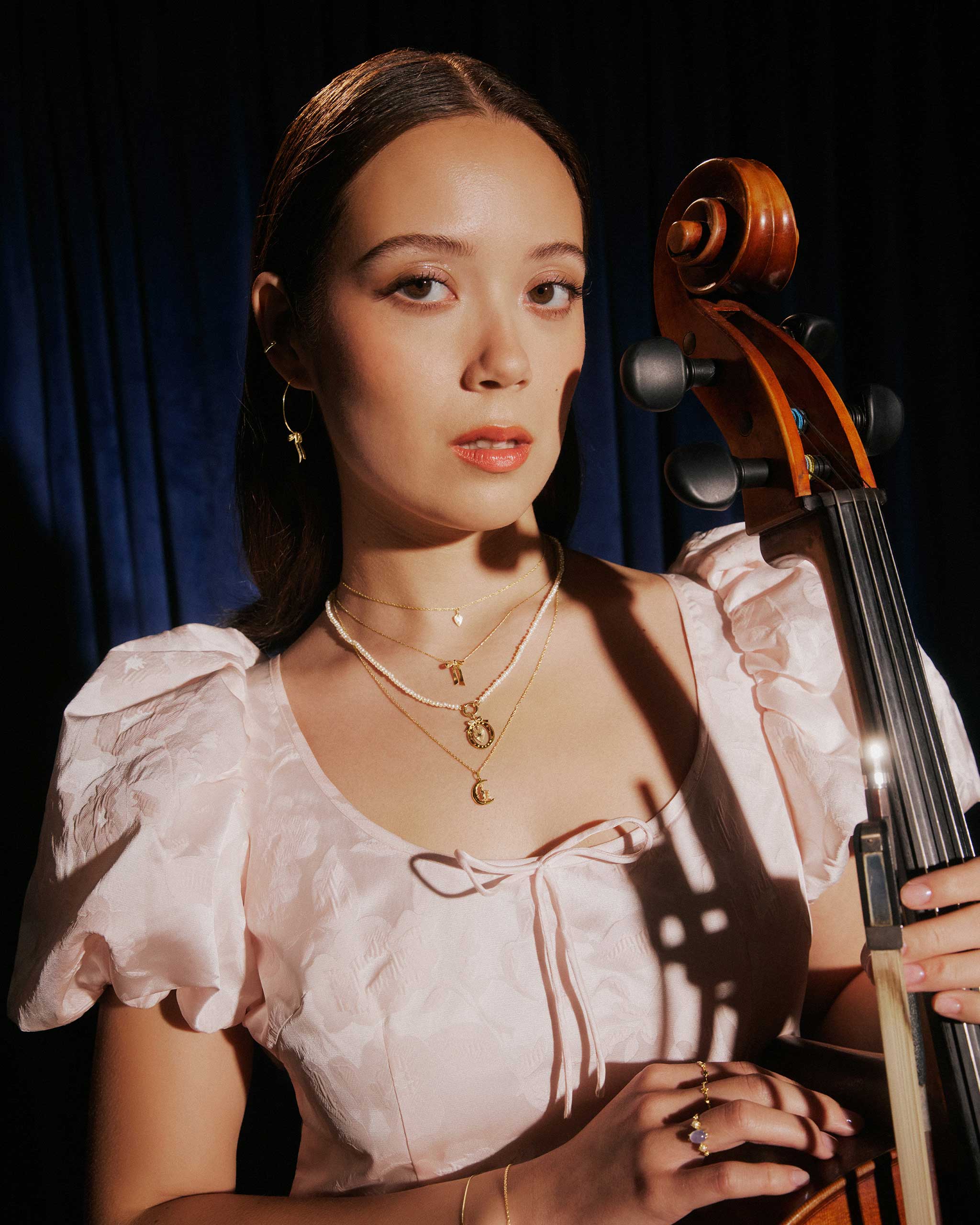 laufey with a violin wearing catbird jewelry for Vogue Philippines