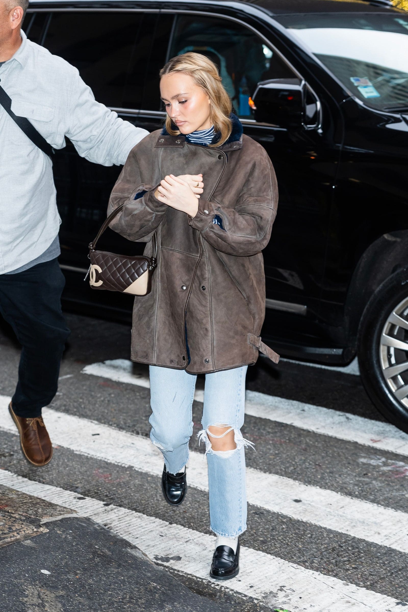 For the daytime: Actress Lily-Rose Depp wears navy and white striped rollneck, light-wash ripped denim straight-leg jeans, black penny loafers, and white socks.