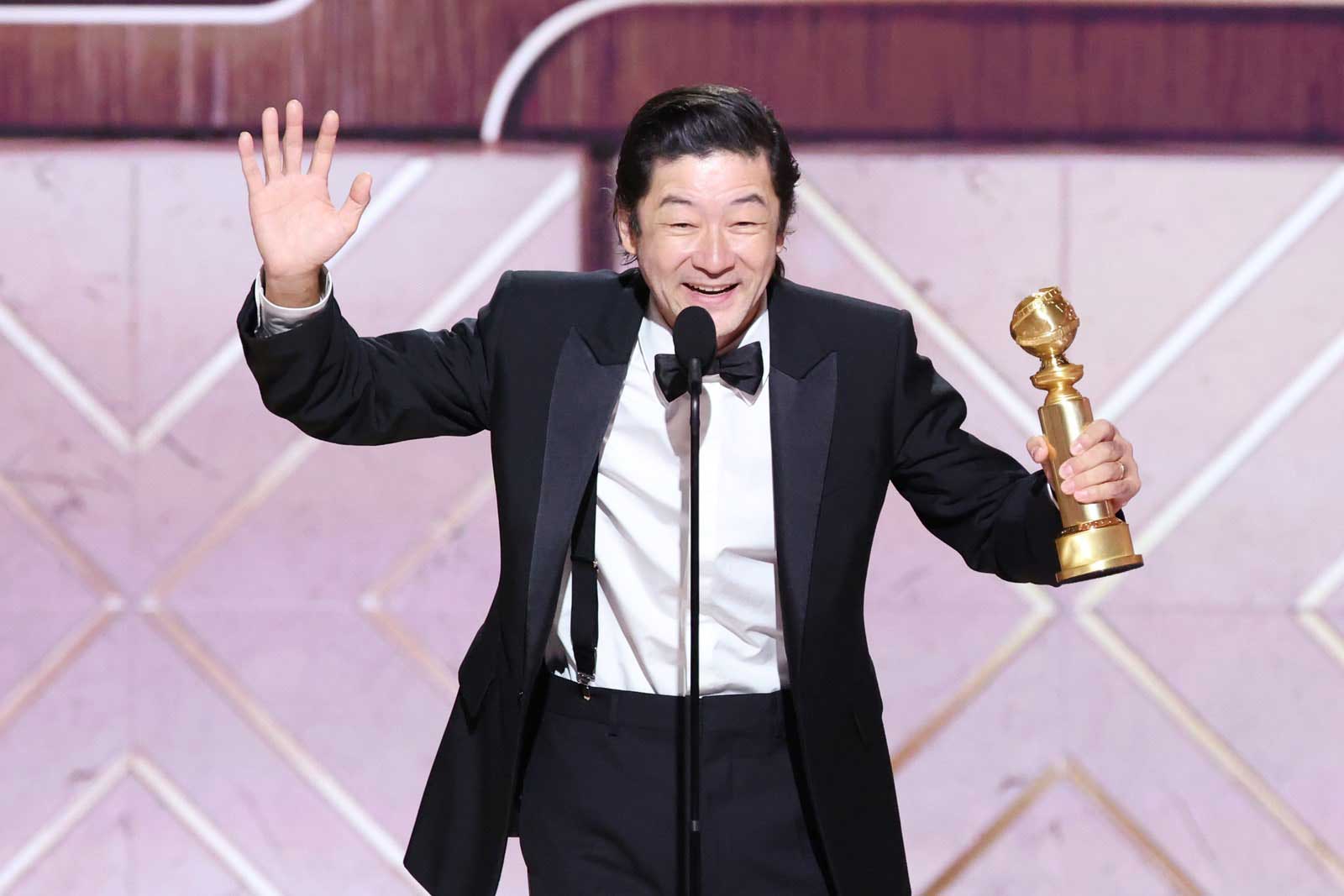 Actor Tadanobu Asano delivers a speech onstage while holding his Golden Globe after winning the award for his role in 