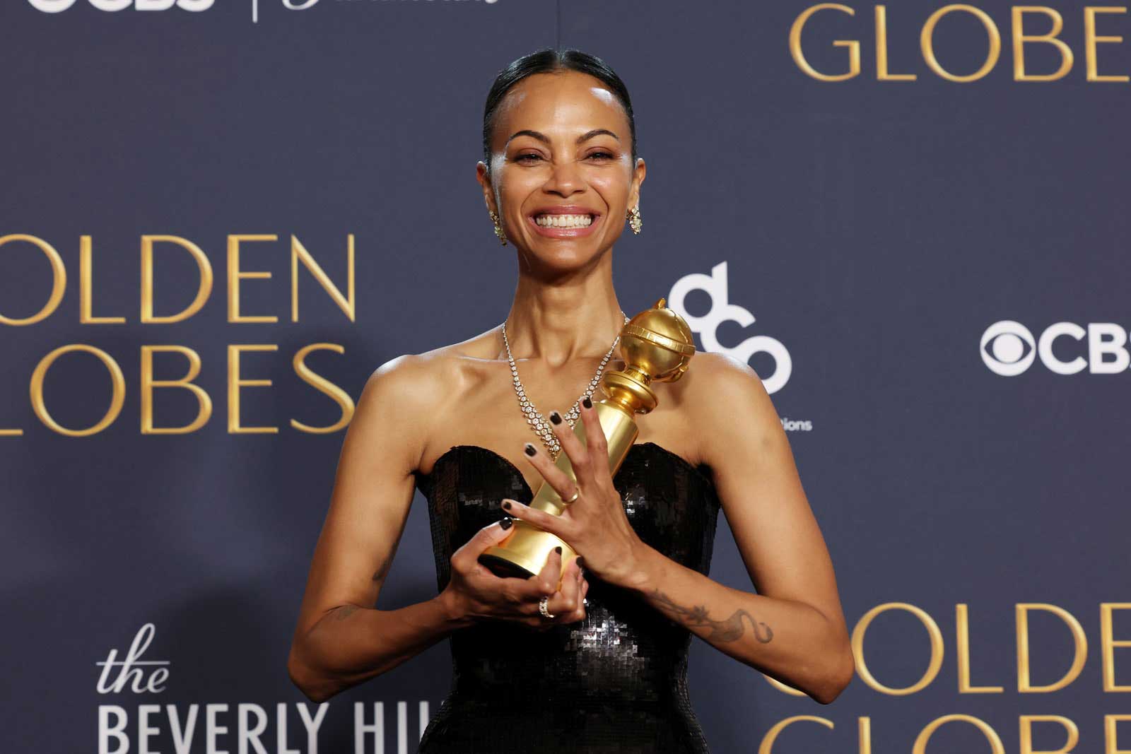 Actress Zoe Saldaña poses for a photo with her Golden Globe.