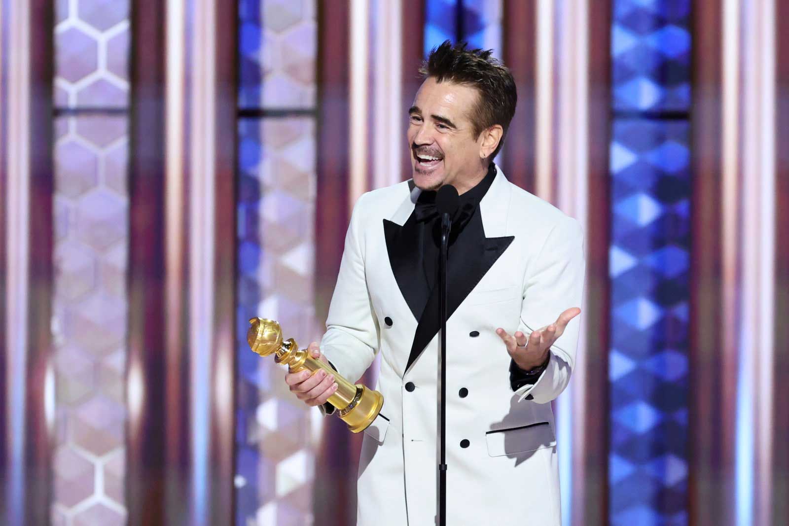 Actor Colin Farrell delivers a speech onstage while holding his Golden Globe after winning it for 