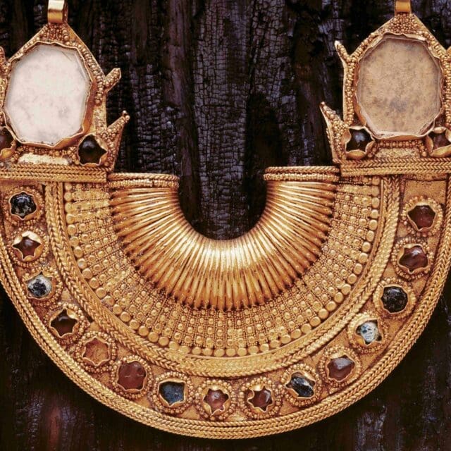 Photograph of a half-moon gold ear ornament, circa 10th to 13th century.