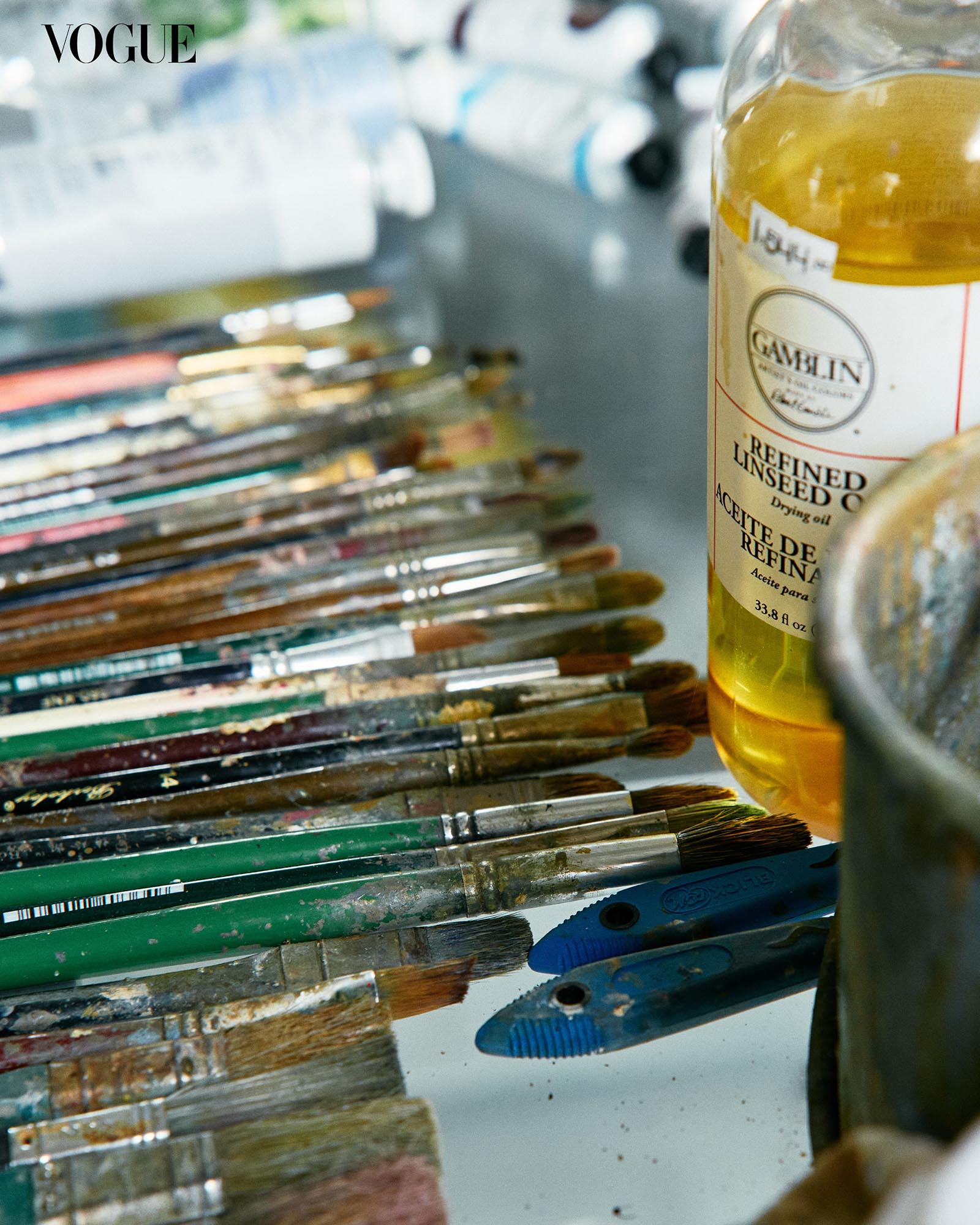 Closeup of paintbrushes and a bottle of refined linseed oil.