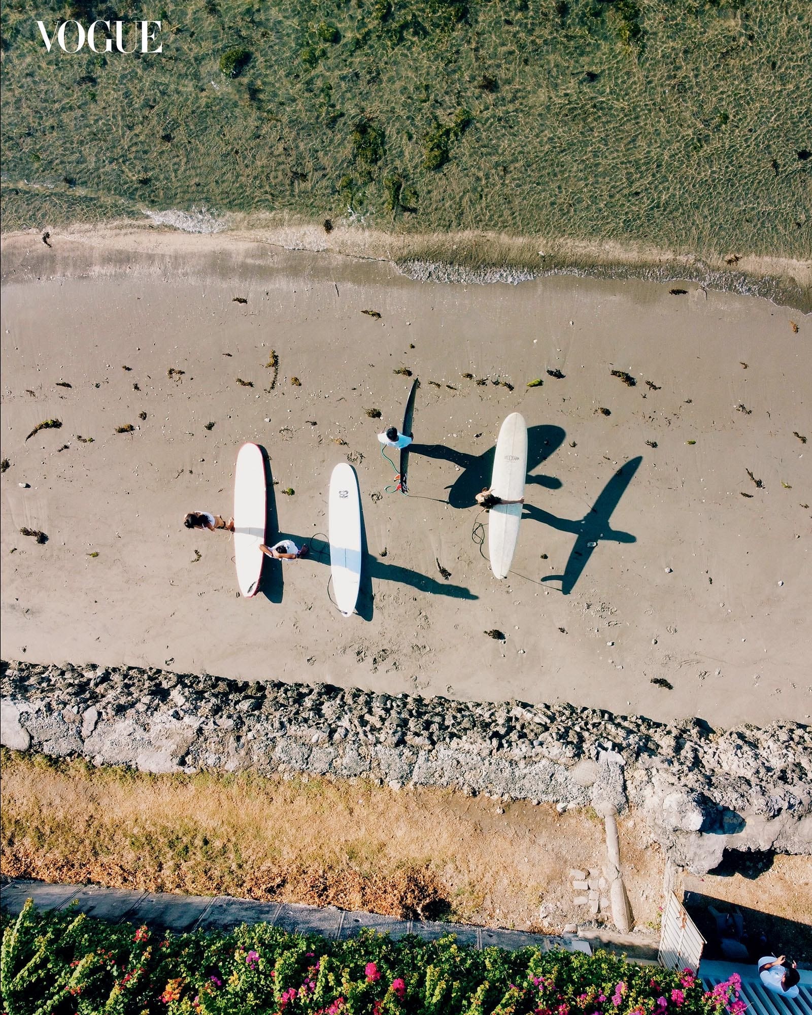 Overhead shot of surfers on a beach.